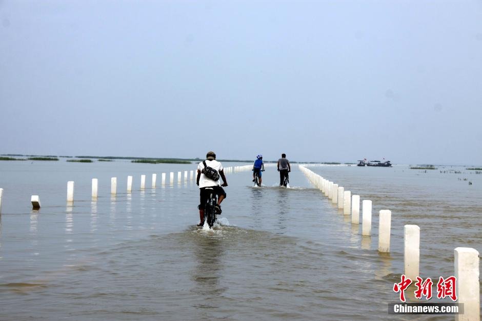 بالصور..تشكيل "طريق فى المياه" بعد ارتفاع المد فى أكبر بحيرة للمياه العذبة بالصين    