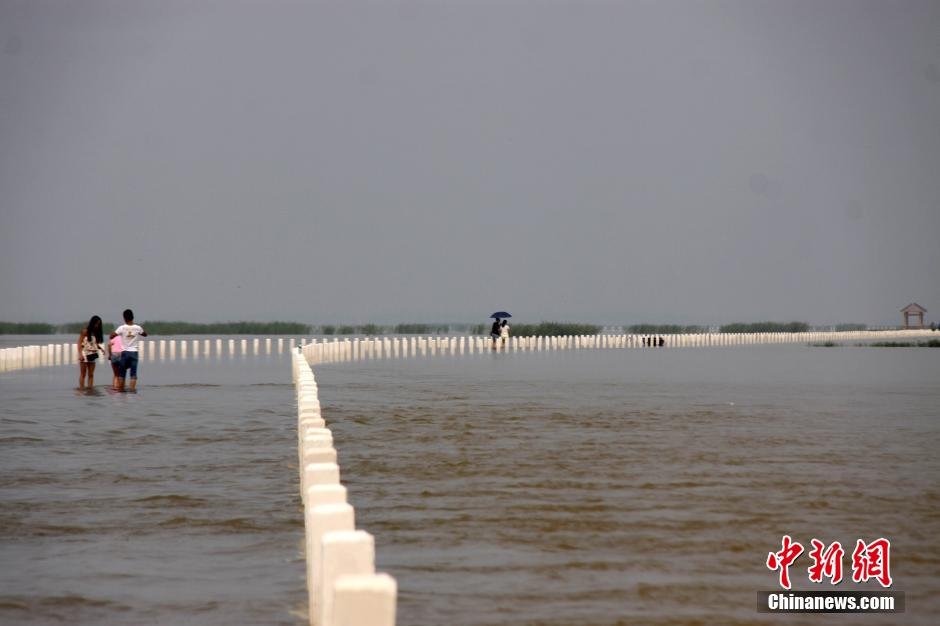 بالصور..تشكيل "طريق فى المياه" بعد ارتفاع المد فى أكبر بحيرة للمياه العذبة بالصين    