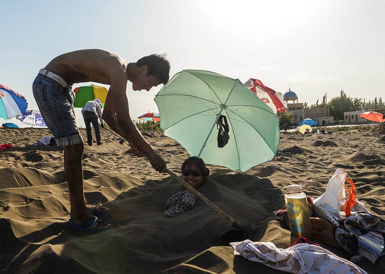 علاج الرمال فى شينجيانغ يجذب العديد من السياح فى الصيف