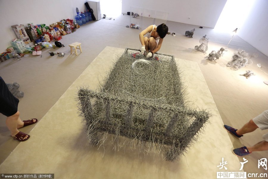 مذهل... فنانة صينية تنام "عارية"على سرير الأسلاك