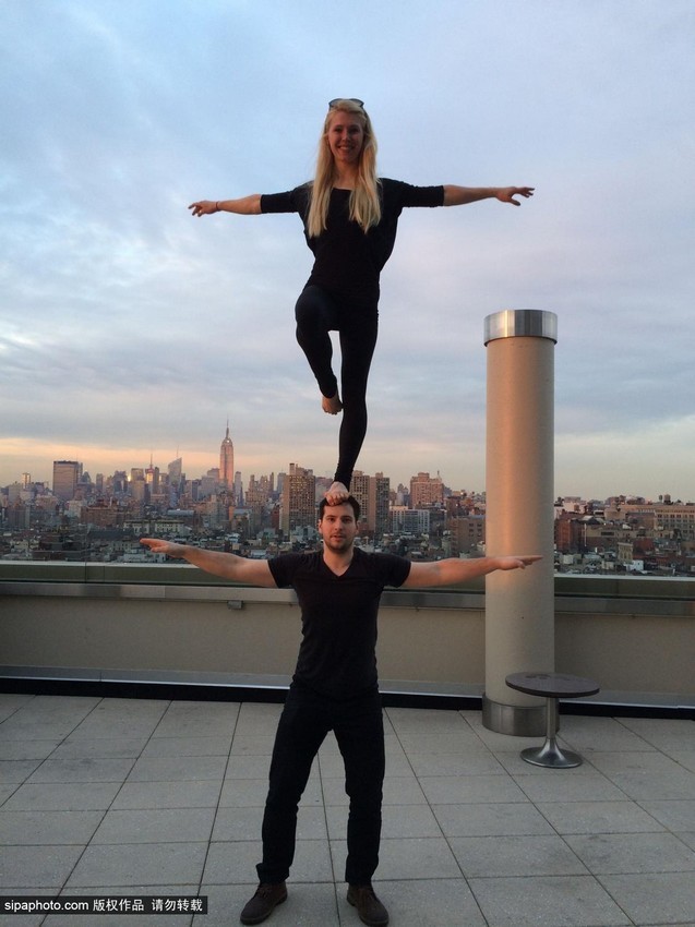 راقصة تتجول فى العالم واقفة على قمة رأس وكتفي عشيقها