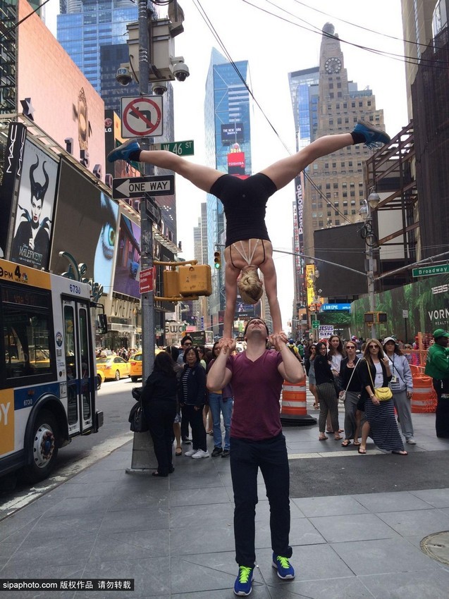 راقصة تتجول فى العالم واقفة على قمة رأس وكتفي عشيقها