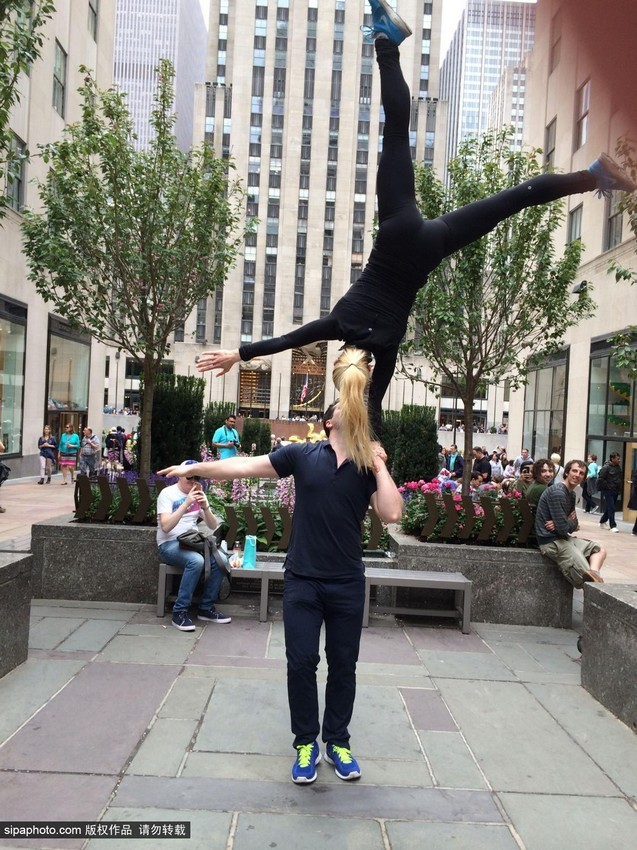 راقصة تتجول فى العالم واقفة على قمة رأس وكتفي عشيقها