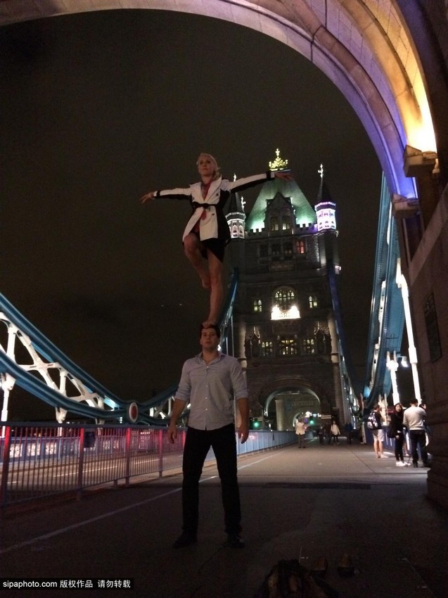 راقصة تتجول فى العالم واقفة على قمة رأس وكتفي عشيقها