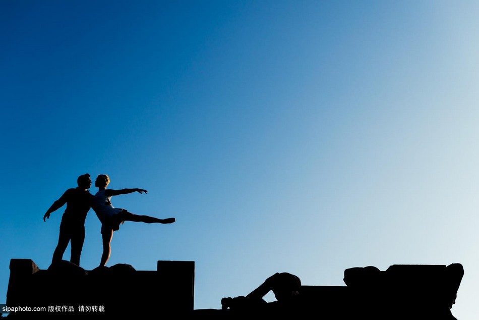 راقصة تتجول فى العالم واقفة على قمة رأس وكتفي عشيقها