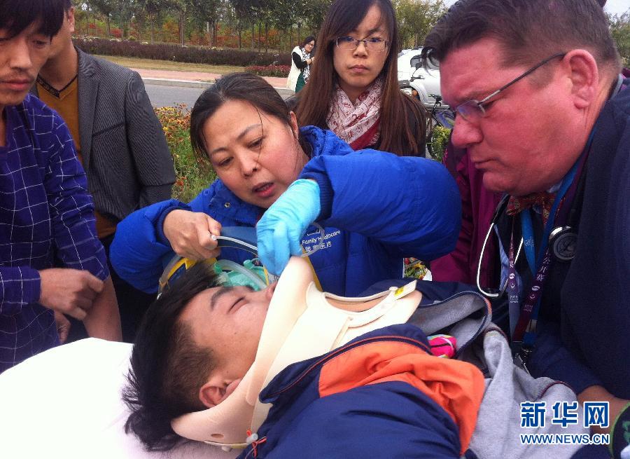 طالب وافد بجامعة تيانجين للتكنولوجيا يتلقى إسعافات أولية بعد تعرضه وعدد من أصدقائه لحادث سير في 12 أكتوبر 2014