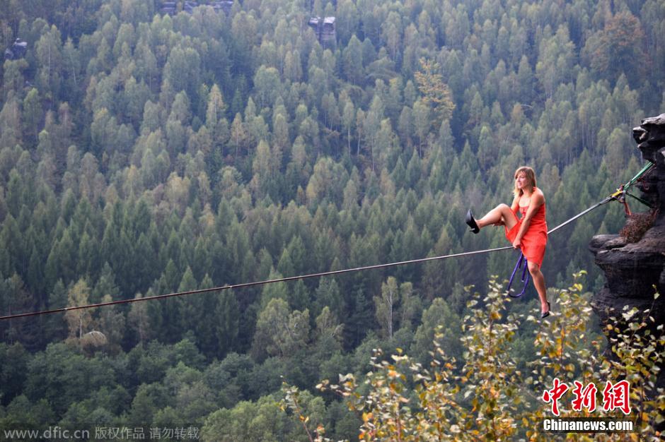 فتاة أمريكية مرتدية أحذية الكعب العالي تعرض المشي الجوي على حبل