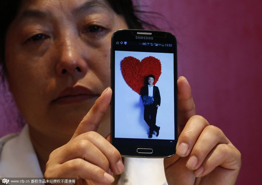 في 18 يوليو 2014، بكين، فنغ شيو هونغ تعرض صورة لإبنها تحتفظ بها في هاتفها، وهي تبكي. إبنها إسمه وانغ هو بين، وكان من بين ركاب آم آش 370. قال لإمه في آخر مكالمة هاتفية قبل الحادث: "أمي، بالحضن. إعتني بنفسك جيدا، سأعود بسرعة لأراك."