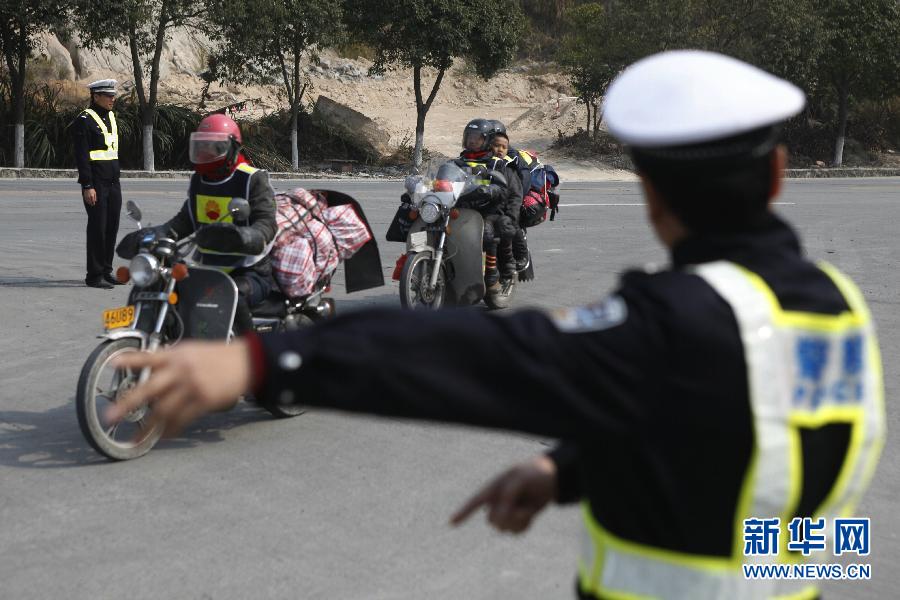 9 فبراير، مدينة تشانغ تشو بمقاطعة فوجيان، شرطي المرور بصدد تنظيم دخول العائدين لمحطة البنزين، لشحن البنزين وأخذ قسط من الراحة.