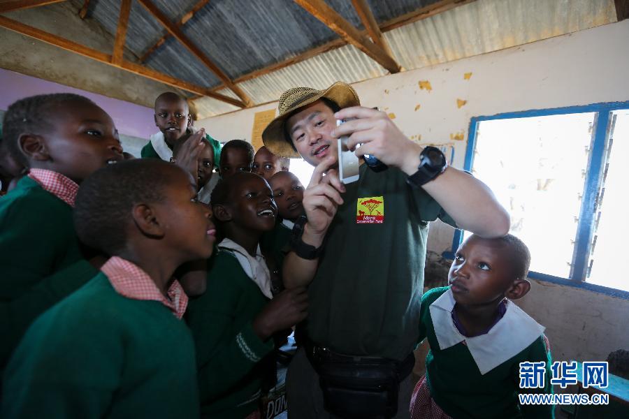 يعرض سمبا للتلاميذ المحليين صور تم التقاطها من خلال الهاتف المحمول في إحدى المدارس الإبتدائية بمحمية أوكنيا بكينيا في 11 مارس الحالي.