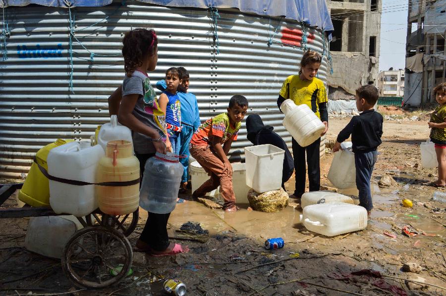 ملأ الأطفال السوريون في حلب البرميل البلاستيكي بالماء.