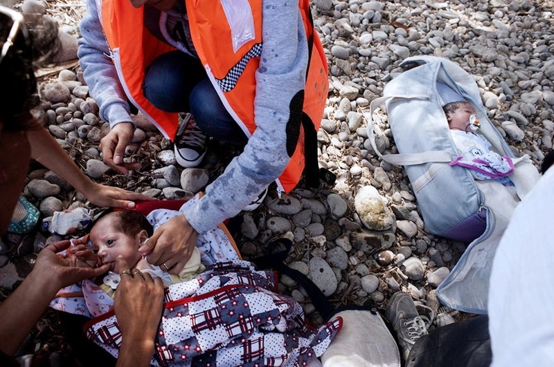 لاجئان سوريان يحملان طفلتيهما في حقيبتين