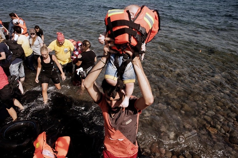 لاجئان سوريان يحملان طفلتيهما في حقيبتين