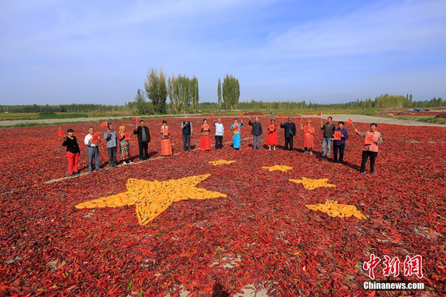 فلاحون في شينجيانغ يشكلون العلم الوطني بالمنتجات الزراعية لاحتفال بعيد ميلاد الوطن