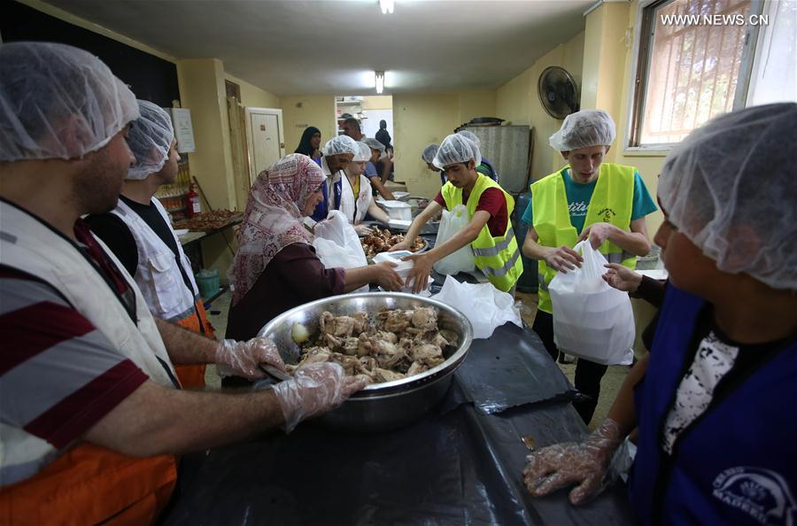 فلسطينيون يصنعون وجبات خيرية للفقراء في الضفة الغربية خلال شهر رمضان