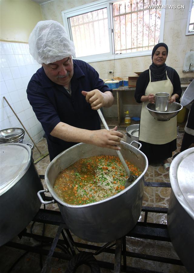 فلسطينيون يصنعون وجبات خيرية للفقراء في الضفة الغربية خلال شهر رمضان