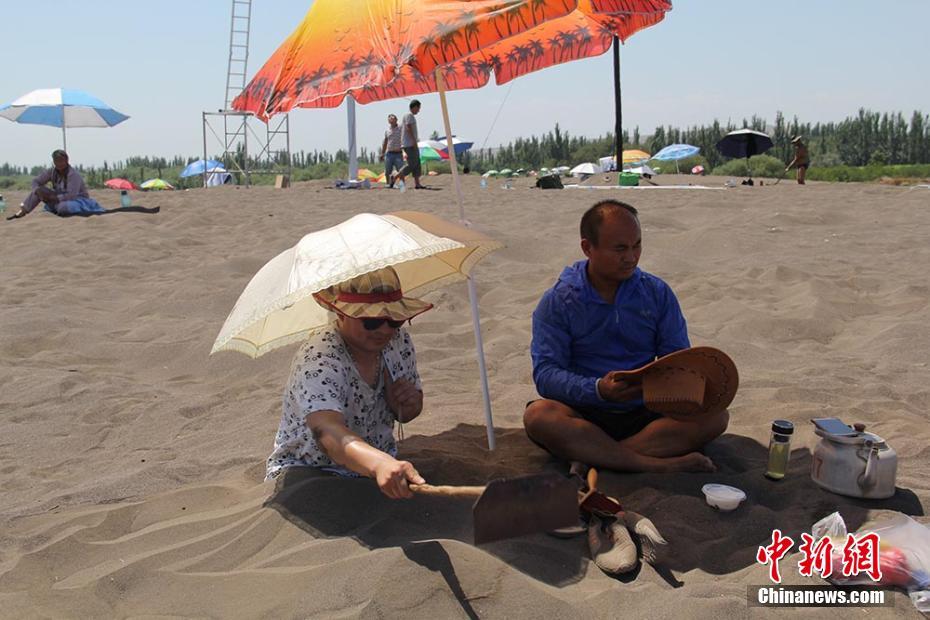 إقبال السياح على العلاج بالرمال الحارة في توربان بشينجيانغ