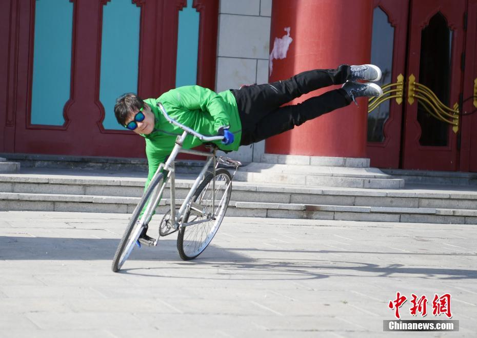 رجل صيني عمره 59 عاما يعرض حركات بهلوانية على الدراجة
