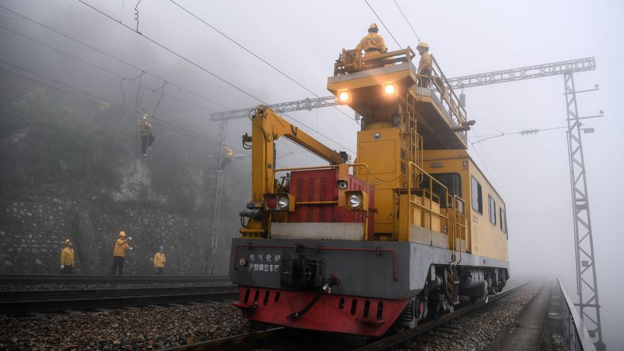 عمال يجرون أعمال الإصلاح على خط السكة الحديدية في جنوبي الصين