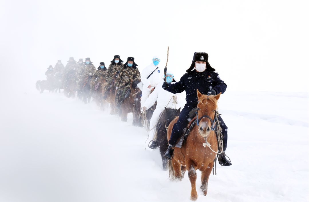شينجيانغ: فريق دورية حدودية  ممتطين خيولهم  في الثلوج الكثيفة