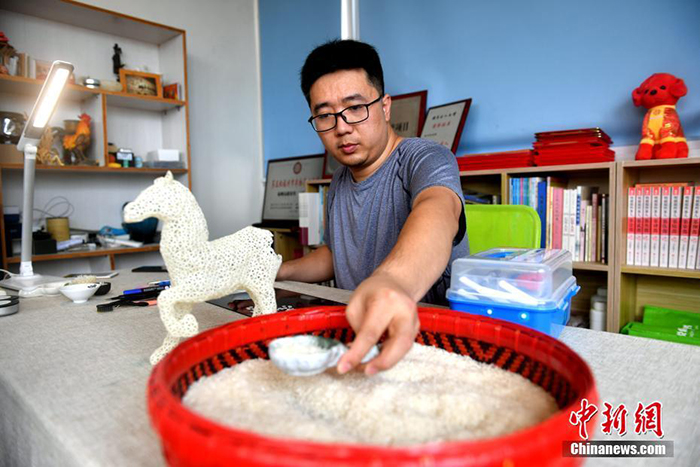 شاب من مدينة فوتشو يصنع تماثيل بحبات الأرز