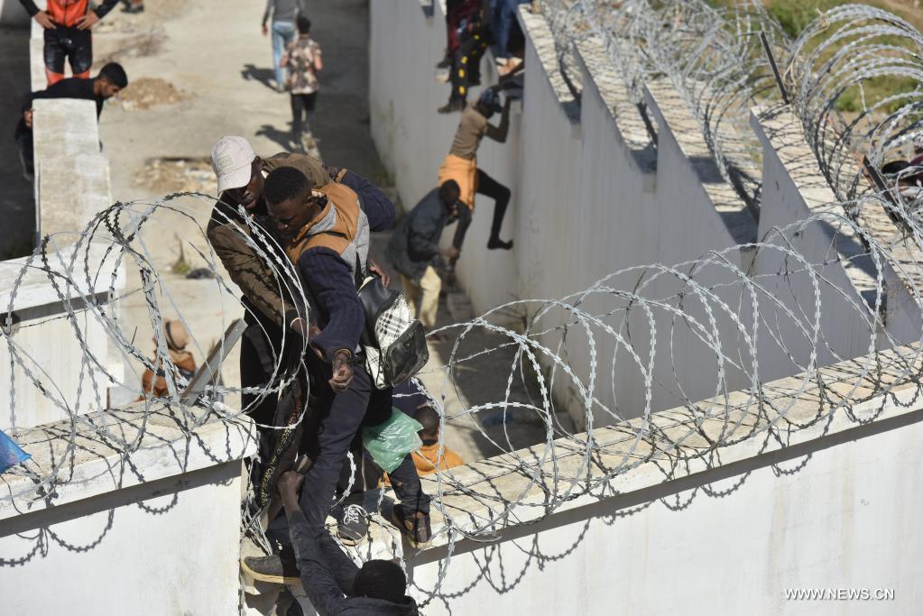 مهاجرون يتسلقون السياج الحدودي لدخول سبتة الإسبانية