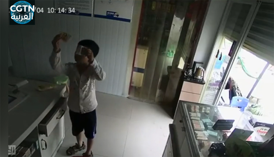 صبيان يظهران الأشياء المراد شراؤها والنقود لكاميرا المراقبة أثناء غياب صاحب المحل