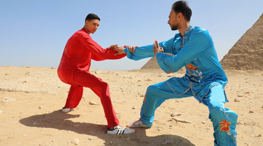 مصريون يمارسون التاي تشي أمام الأهرامات