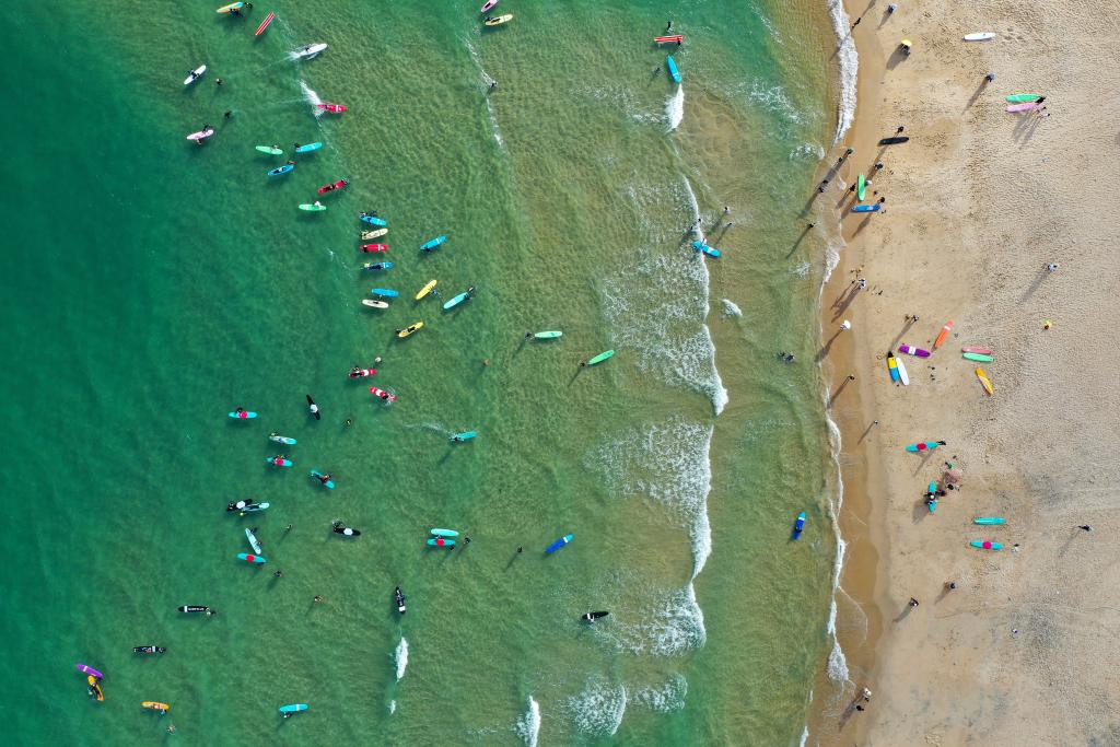 سياح يركبون الأمواج في سواحل جنوبي الصين