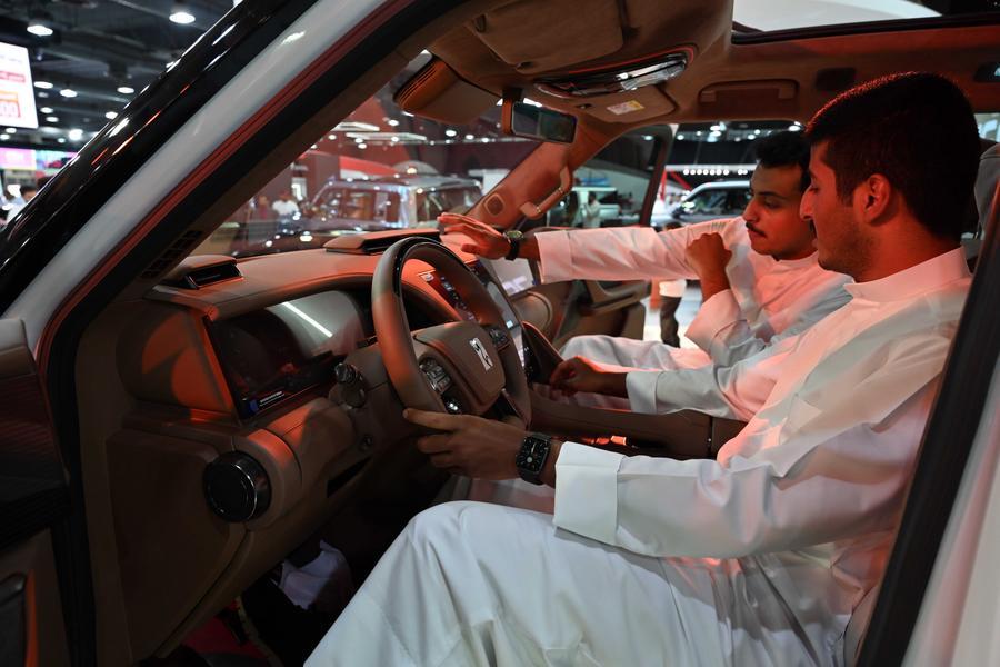 في الصورة الملتقطة يوم 22 سبتمبر 2025، زوار يجلسون داخل مركبة في جناح العلامة التجارية الصينية للسيارات "بي واي دي" خلال معرض السيارات العالمي في محافظة حولي، الكويت. (شينخوا)