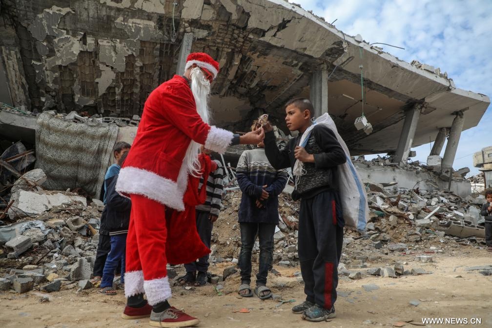 فلسطيني في زي بابا نويل يوزع الحلوى في مدينة غزة