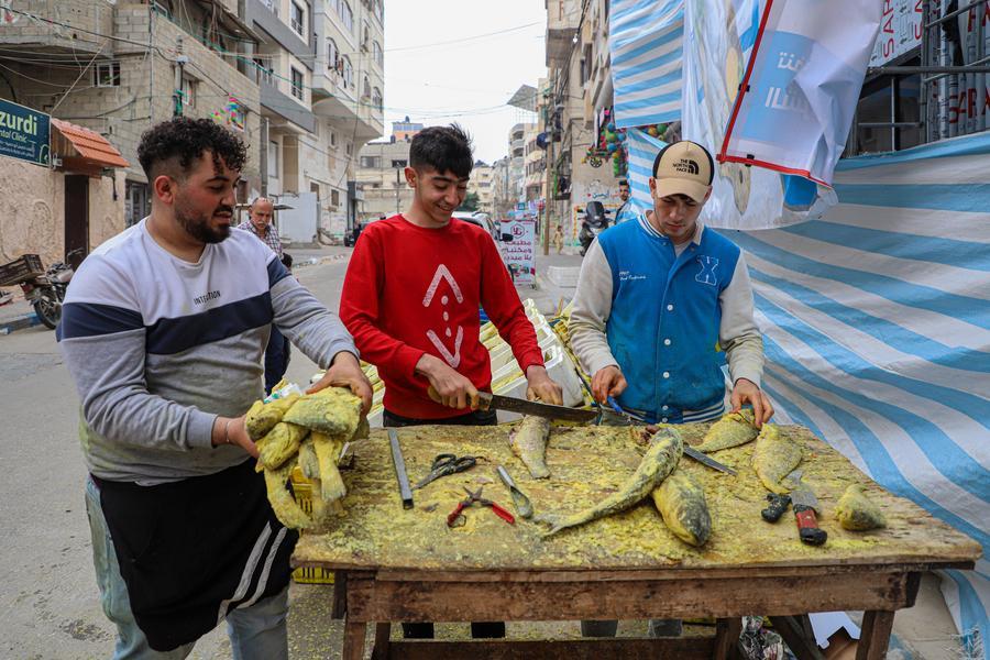 بائعون فلسطينيون يبيعون السمك المملح المعروف باسم الفسيخ في سوق قبيل عيد الفطر بمدينة غزة، يوم 19 أبريل 2023.(شينخوا)